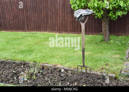 Gants de jardinage en appui sur la poignée d'outils de jardinage Banque D'Images