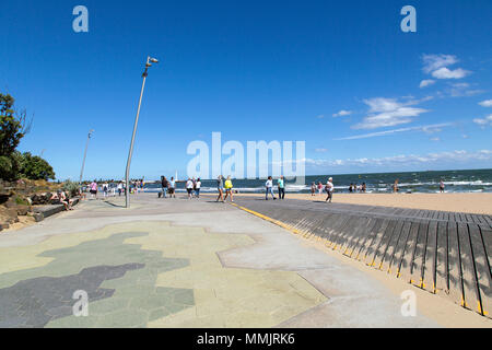 Melbourne, Australie : le 25 mars 2018 : les touristes à pied le long de St Kilda Promenade dans le soleil avec un fond de ciel bleu clair et copier l'espace. Banque D'Images
