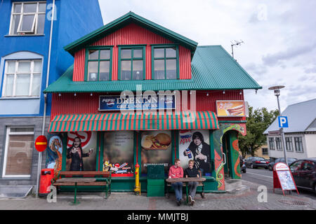 Couple assis à l'extérieur dans un restaurant-grill Drekinn à Reykjavík, Islande Banque D'Images