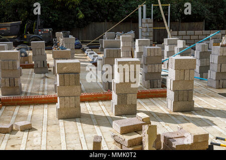 Parpaings empilés sur le sol d'une nouvelle maison en construction sur un jardin de banlieue résidentielle bâtiment intercalaire site, Surrey, Angleterre du Sud-Est Banque D'Images