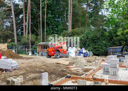 Chariot télescopique Manitou MT 1440 sur un jardin de banlieue résidentielle bâtiment intercalaire site avec des matériaux de construction, Surrey, Angleterre du Sud-Est Banque D'Images