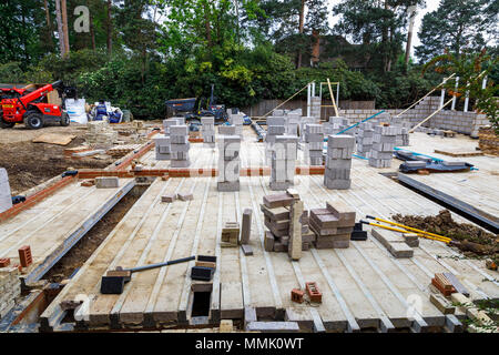 Parpaings empilés sur le sol d'une nouvelle maison en construction sur un jardin de banlieue résidentielle bâtiment intercalaire site, Surrey, Angleterre du Sud-Est Banque D'Images