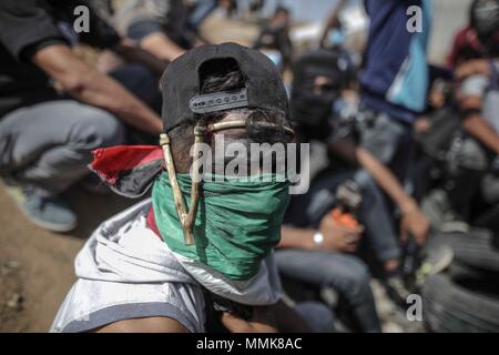 La bande de Gaza. Le 11 mai, 2018. Un manifestant palestinien prend part à des affrontements avec des soldats israéliens près de la frontière entre l'est de Gaza et Israël le 11 mai 2018. Un Palestinien a été tué et 973 autres ont été blessées vendredi lors d'affrontements entre des centaines de manifestants palestiniens et soldats israéliens près de la frontière entre l'est de Gaza et Israël. Credit : Wissam Nassar/Xinhua/Alamy Live News Banque D'Images