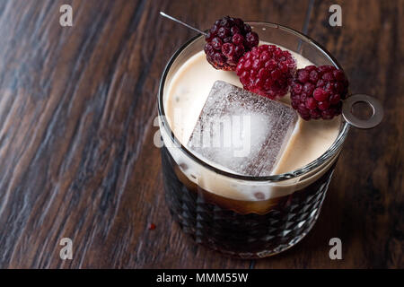 Black / Dark Beer Cocktail avec des mûres et de la glace sur la surface en bois. Concept de boisson. Banque D'Images