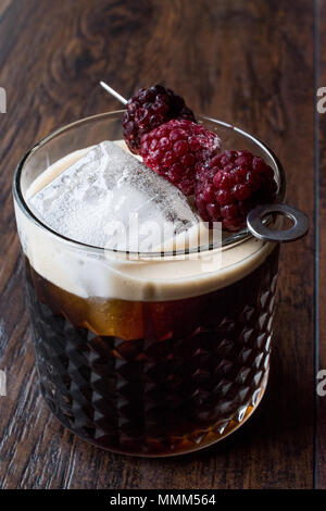 Black / Dark Beer Cocktail avec des mûres et de la glace sur la surface en bois. Concept de boisson. Banque D'Images