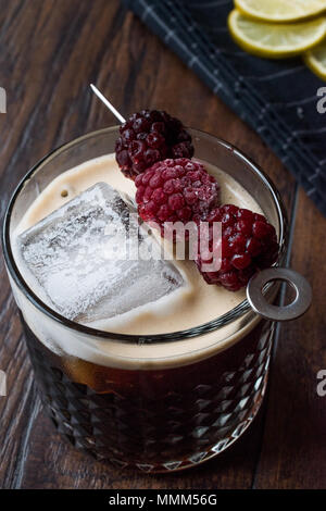 Black / Dark Beer Cocktail avec des mûres et de la glace sur la surface en bois. Concept de boisson. Banque D'Images