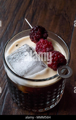 Black / Dark Beer Cocktail avec des mûres et de la glace sur la surface en bois. Concept de boisson. Banque D'Images