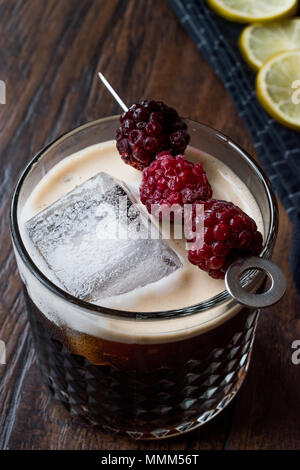 Black / Dark Beer Cocktail avec des mûres et de la glace sur la surface en bois. Concept de boisson. Banque D'Images