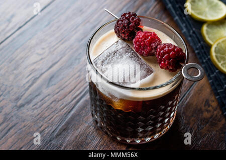 Black / Dark Beer Cocktail avec des mûres et de la glace sur la surface en bois. Concept de boisson. Banque D'Images