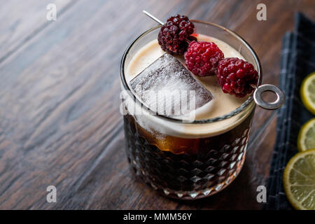 Black / Dark Beer Cocktail avec des mûres et de la glace sur la surface en bois. Concept de boisson. Banque D'Images