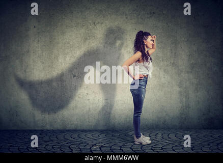 Vue latérale d'une femme d'imaginer d'être un super héros à la aspirait. Banque D'Images