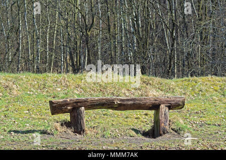 Vieux banc en bois rustique sur un terrain avec une forêt en arrière-plan. Boberger Niederung nature reserve à Hambourg, Allemagne Banque D'Images