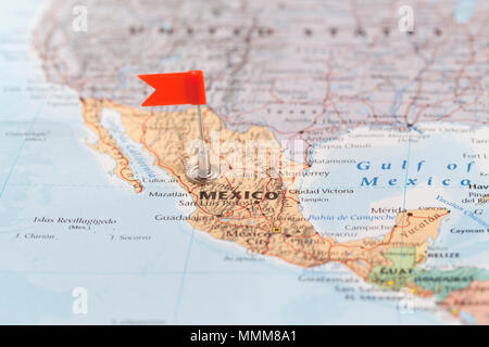 Petit drapeau rouge marquant le pays d'Amérique du Sud du Mexique sur une carte du monde. Banque D'Images