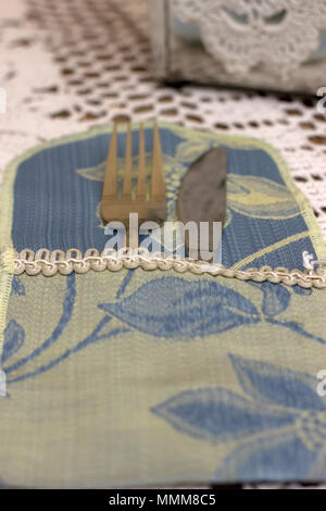 Cuillère et fourchette en emballage de tissus sur un fond clair Banque D'Images