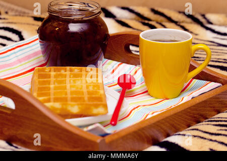 Petit déjeuner au lit sur un plateau - gaufres, thé, confiture Banque D'Images