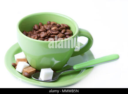 La green cup avec une cuillère avec des grains de café et des morceaux de sucre sur un fond clair Banque D'Images