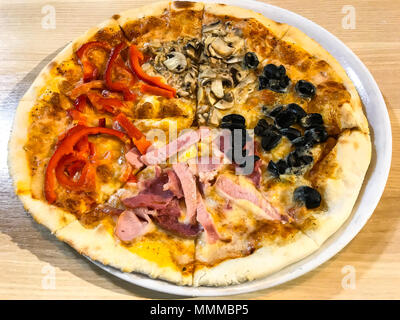 Des pizzas avec des obturations en différentes tables en bois. Studio Photo Banque D'Images