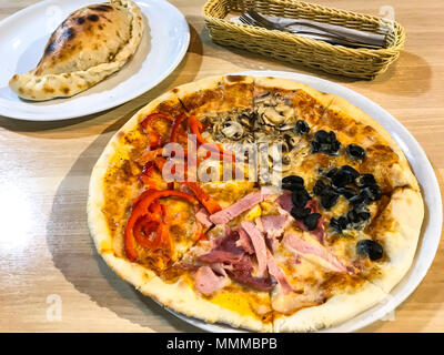 Des pizzas avec des obturations en différentes tables en bois. Studio Photo Banque D'Images