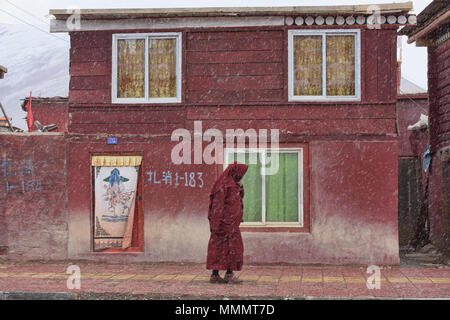 Moine tibétain marche dans la neige, Yarchen Gar, Sichuan, Chine Banque D'Images