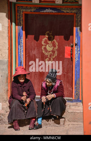 Pèlerin tibétain fait tourner un moulin à prières à l'extérieur de la Sainte Ecriture Imprimerie Bakong monastère à Dege, Sichuan, Chine Banque D'Images