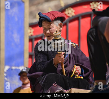 Pèlerin tibétain fait tourner un moulin à prières à l'extérieur de la Sainte Ecriture Imprimerie Bakong monastère à Dege, Sichuan, Chine Banque D'Images