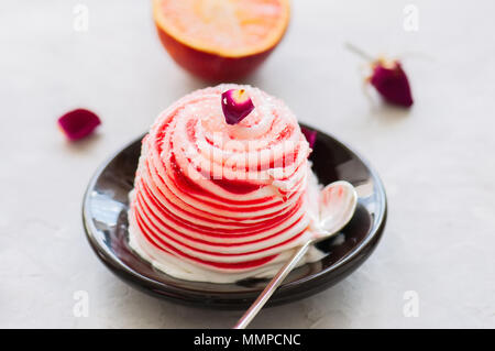 L'eau de rose orange sanguine et glace vanille servie sur une assiette. Arrière-plan de pierre blanche. Banque D'Images