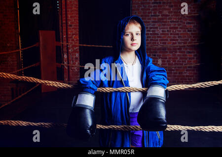 Cute blonde boy boxer avec des gants noirs et la robe sur l'anneau Banque D'Images