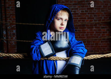 Cute blonde boy boxer avec des gants noirs et la robe sur l'anneau Banque D'Images