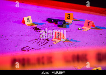 Une empreinte sanglante et d'armes à feu sont marqués avec des preuves des marqueurs dans une scène de crime. Ruban cordon peut être vu dans l'avant-plan. Banque D'Images