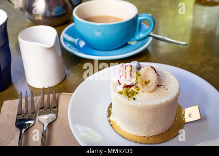 Petit gâteau au chocolat blanc sur un panneau de gâteau d'or Banque D'Images