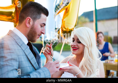 Mariée et le marié à l'autre leur gâteau de mariage Banque D'Images