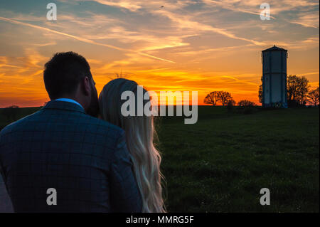 Jeune couple regardant le coucher du soleil Banque D'Images