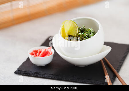 Algues Wakame sain ou chuka, avec vinaigrette au sésame et ginfer sur ardoise board with copy space Banque D'Images