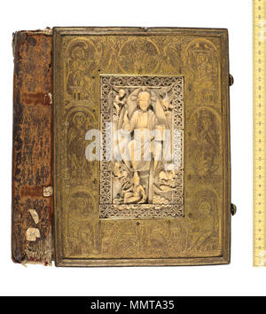 . Plaque d'Ivoire gravée dans le métal. Le flamand et/ou l'allemand, début au milieu 11e siècle. L'ivoire, attribué à Liège au début du 11e siècle, montre le Christ en triomphe sur terre et de personnifications (endommagé), de l'océan avec des symboles des quatre évangélistes, c'est peut-être un peu plus tôt que la plaque en métal doré gravé qui fixe à l'épaisse planche de bois de la première de couverture. Le manuscrit à l'intérieur a été attribuée à l'Allemand scriptorium de Lorsch vers le milieu 11e siècle. Cependant, le métal s'adapte directement, puisque l'ange gravé au bas fait écho à une illumination Banque D'Images