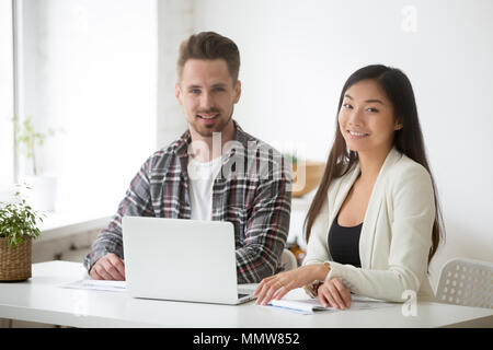 Smiling young asian businesswoman and Caucasian businessman prof Banque D'Images
