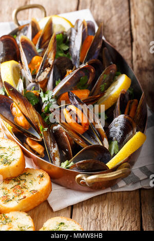 Les moules dans le vin avec le persil et le citron. Les fruits de mer. Les palourdes dans les coquilles. En-cas délicieux pour les gourmands. vertical, style rustique Banque D'Images