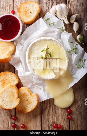 Camembert au four au thym et l'ail servi avec du pain grillé sur la table. Haut Vertical Vue de dessus Banque D'Images