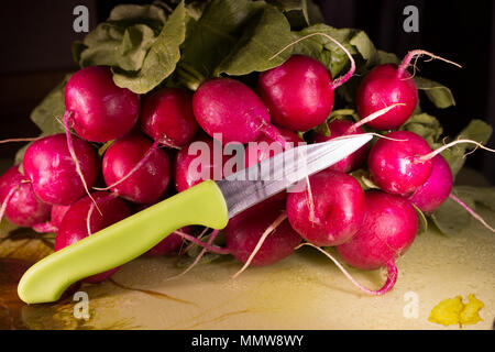 Les radis ensemble avec couteaux on cutting board Banque D'Images