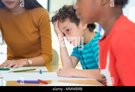 Caucase boy kid avec tristesse l'émotion assis en classe préscolaire à la maternelle.bulying concept de dépression Banque D'Images