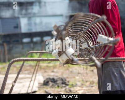 Les mains des travailleurs mettez des gants à l'aide de la main pour fil de fer pour attacher la structure de la maison ou du bâtiment. Banque D'Images