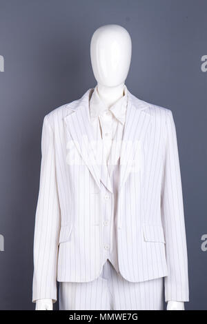 Mannequin en costume blanc, fond gris. Banque D'Images