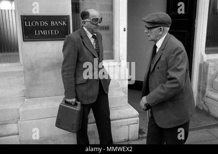 Courrier bancaire livrant de l'argent etc 1970s Royaume-Uni. Un homme de sécurité d'âge moyen qui livre de l'argent dans une caisse à une banque de rue et porte des vêtements de protection, juste des lunettes HOMER SYKES des années 1979 70 Banque D'Images