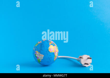 Modèle globe et câble électrique sur fond bleu. Un minimum d'économies d'énergie concept créatif. L'espace pour copier. Banque D'Images