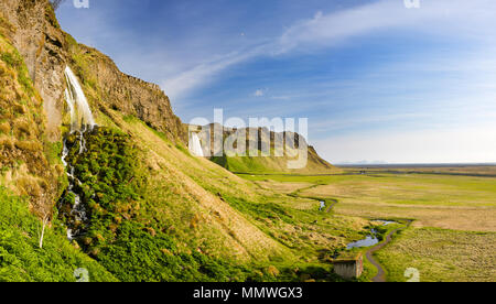 Voir à côté d'une falaise avec l'Seljalandsfoss en arrière-plan, de l'Islande. Banque D'Images