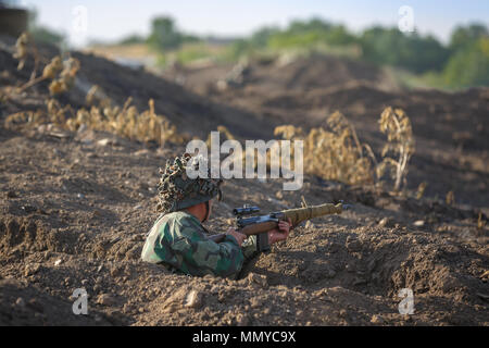 RYAZHENOE, Taganrog, Russie, 20 août 2017 : Soldat avec un fusil de sniper est dans une tranchée Banque D'Images