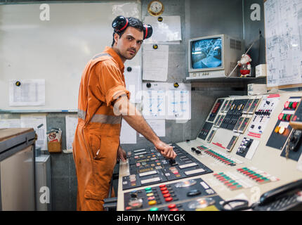 Officier mécanicien de marine démarre ou arrête le moteur principal de l'expédition dans le prix des machines. Le travail des marins. Banque D'Images