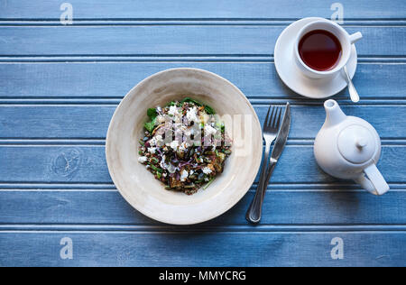 Salade Mixte en santé avec le thé sur un tableau bleu rustique Banque D'Images