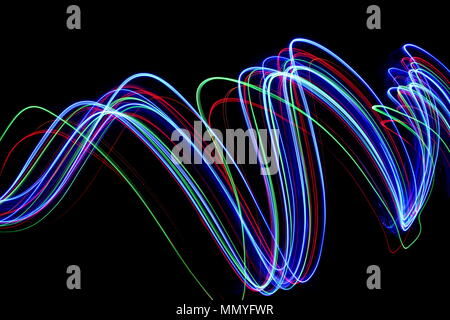 Lumière multi couleur peinture photographie, bleu électrique, rouge et vert, de rides et des vagues de couleurs vives en lignes parallèles sur un fond noir Banque D'Images