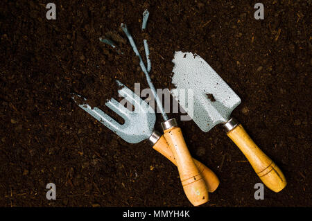 Outils de jardinage dans le sol fertile vue supérieure Banque D'Images