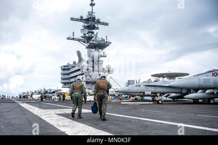 170804-N-SJ730-437 OCÉAN ATLANTIQUE (16 août 2000 4, 2017) Royaume-Uni Commandant Groupe aéronaval du cdre. Andrew Betton, OBE, gauche, et le lieutenant Cmdr. Sean Stuart, un pilote de l' 'Blacklions de Strike Fighter Squadron (VFA) 213, promenade sur le pont de vol classe Nimitz le porte-avions USS George H. W. Bush (CVN 77) après un vol au cours de l'exercice guerrier Saxon, le 4 août 2017. Saxon Warrior est un États-Unis et Royaume-Uni co-organisé l'exercice de groupe aéronaval qui démontre l'interopérabilité et la capacité de réagir aux crises et de décourager les menaces potentielles. (U.S. Photo de la marine par la communication de masse Special Banque D'Images